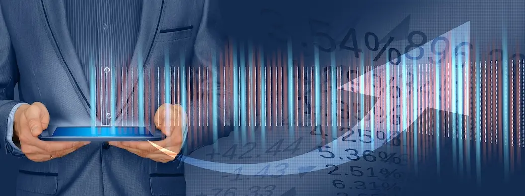 Geschäftsmann mit Tablet vor Finanzdaten und Kursdiagramm – Symbolbild für Bauzinsen-Entwicklung und Immobilienfinanzierung 2026