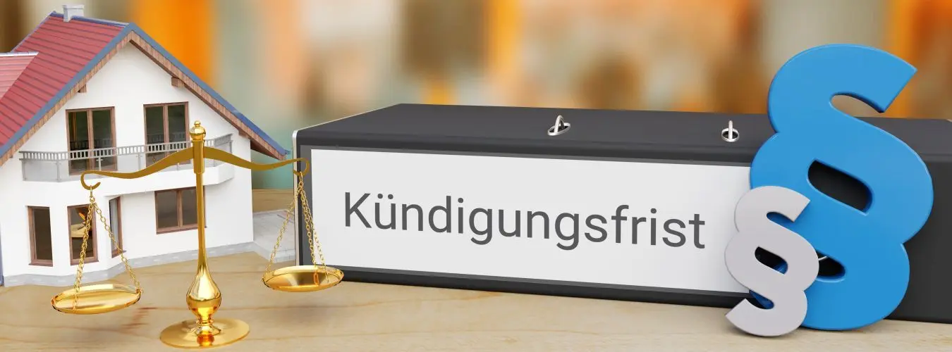 Kündigung Mietvertrag. Akten-Ordner beschriftet mit dem Wort Kündigungsfrist liegt neben einem Haus, einer Waage sowie Paragrafen-Zeichen auf einem Schreibtisch. Skyline einer Stadt im Hintergrund