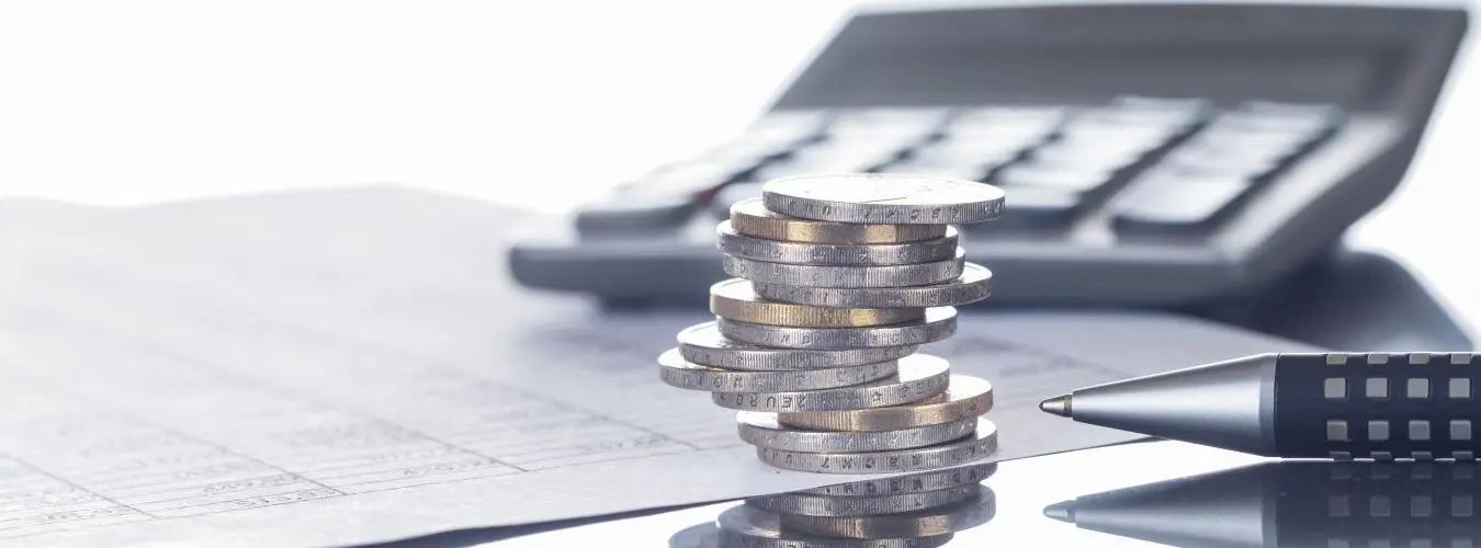 Finanzen, Euro, Münzstapel auf Tabellen mit Stift und Taschenrechner