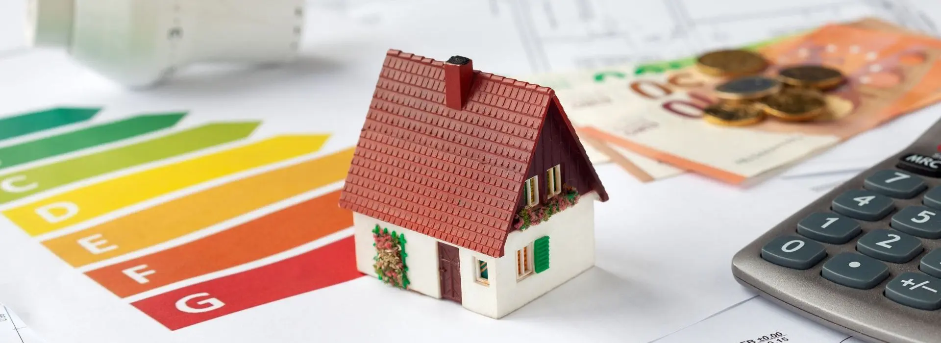 Symbolbild Energieberatung mit Bauplänen, Rechner, Geld und Thermostat - Beantragung von Fördermitteln zur energetischen Sanierung einer Immobilie